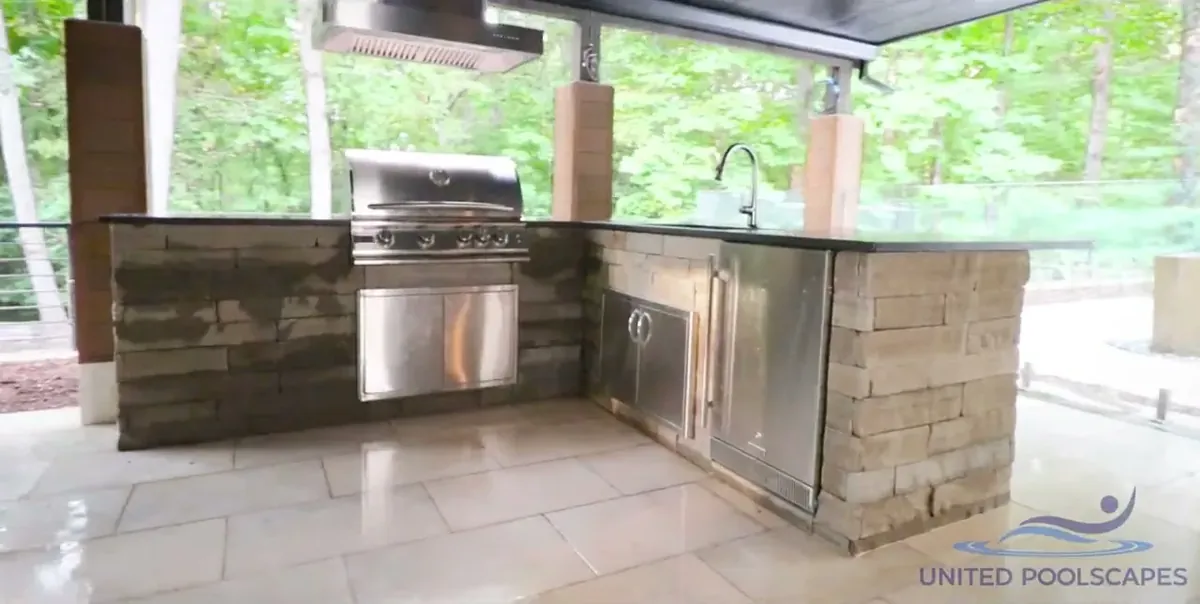 Covered outdoor kitchen with a grill, sink and storage, from one of Christian’s project films